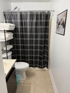 ein Bad mit einem schwarzen Duschvorhang und einem WC in der Unterkunft DukeHaven near Northlake, Uptown, Route to Airport in Charlotte