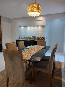 a dining room with a glass table and chairs at Cobertura Ilha De Capri in Macapá