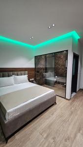 a bedroom with a large bed and a blue lighting at Hotel Agron in Tirana +17 photos