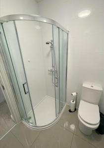 a bathroom with a glass shower with a toilet at Modern Apartment, Free Parking, Smart TV, Sofa Bed in Bedford