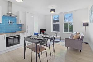 a kitchen and living room with a table and chairs at Modern Apartment, Free Parking, Smart TV, Sofa Bed in Bedford