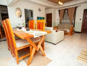 a dining table and chairs in a living room at Ukarimu Hosts in Arusha