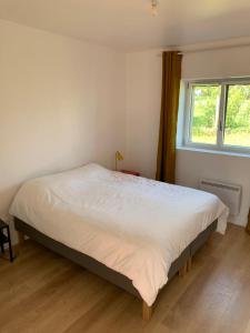 a bedroom with a large bed with a window at Le 13 bis in Champtoceaux