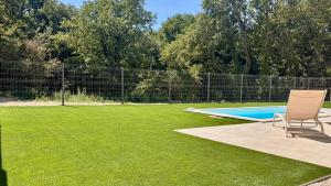 a lawn with two chairs and a swimming pool at Villa neuve avec piscine in Allan