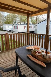 a picnic table on a deck with food on it at Mobil home Capbreton in Capbreton