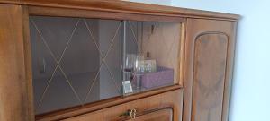 a wooden cabinet with a glass door with a shelf at Chez Elsa et Agou - chambre confortable chez l'habitant in Courtepin