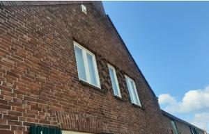 three windows on the side of a brick building at BonAparte in Hank