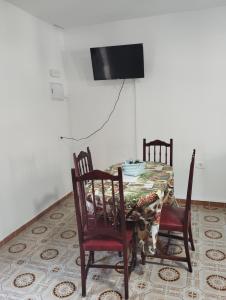 a dining room table with two chairs and a television at Vivienda Vacacional Casa Uca in San Pedro