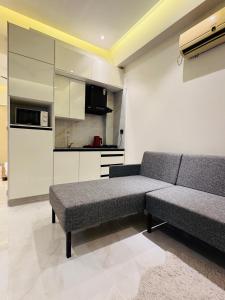 a living room with a couch and a kitchen at Anayah Fam Rental in Rawalpindi
