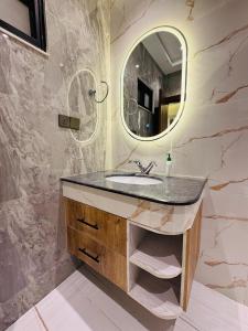 a bathroom with a sink and a mirror at Anayah Fam Rental in Rawalpindi