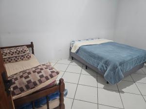 a bedroom with a bed and a chair at Apto em Itapecerica da Serra in Itapecerica da Serra