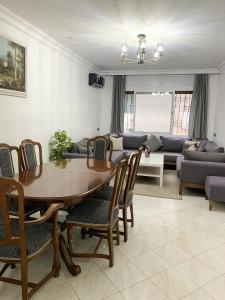 ein Wohnzimmer mit Tisch und Stühlen und einer Couch in der Unterkunft Vacances sans effort au centre de la ville in Tangier