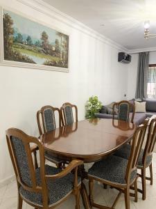 ein Esszimmer mit einem Holztisch und Stühlen in der Unterkunft Vacances sans effort au centre de la ville in Tangier