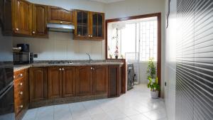 eine Küche mit Holzschränken und einer Spüle in der Unterkunft Vacances sans effort au centre de la ville in Tangier + 14 Fotos