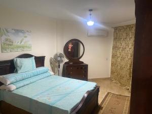 a bedroom with a bed with a dresser and a mirror at قرية لاجولى السخنه للعائلات فقط in Ain Sokhna +12 photos
