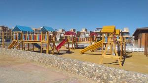 a row of colorful playground equipment on a beach at قرية لاجولى السخنه للعائلات فقط in Ain Sokhna