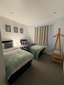 a bedroom with two beds and a wooden ladder at Spacious John York House & Parking in Doncaster