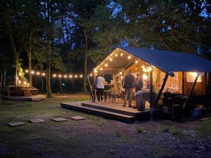 a group of people standing in a tent at night at Tente Lodge in Saint-Paul-en-Born