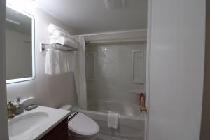 a bathroom with a sink and a toilet and a tub at Victoria Gorge Waterway Vacation Home in Victoria