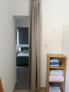 a small bedroom with a bed and a curtain at My Lovely Apt in Tel Aviv