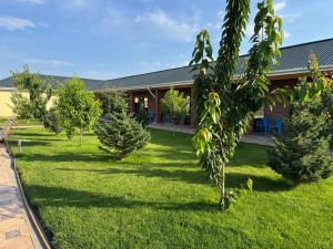 a yard with trees in front of a house at Шатман in Chyrpykty