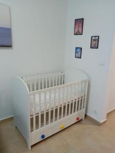 a white crib in a room with pictures on the wall at Casa Alimonda in Genoa