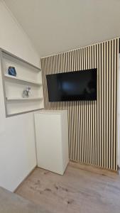 a room with a flat screen tv on a wall at Apartmani Kuzman in Ždrelac +20 photos