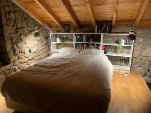 a bedroom with a large bed in a stone wall at Cabaña Pasiega Lo Bartulo in La Concha