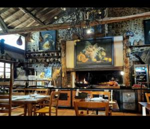 ein Restaurant mit Tischen und Stühlen und einem Gemälde an der Wand in der Unterkunft 85 m2 de plain-pied, 2chambres, 3 lits dans maison confortable avec vue sur la vallée et les Pyrénées ariégeoises, grande terrasse avec barbecue et parking gratuit in Castéras