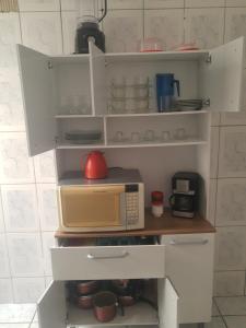 a kitchen with a microwave on top of a counter at Cantinho da val in Aparecida