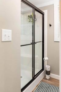 una puerta de ducha de cristal en una habitación con alfombra en Tikabee Timbers - Minutes to Mentone & Desoto Falls, en Mentone