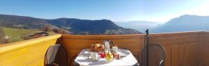 a table and chairs on a balcony with a view of mountains at Wohnung Mölten in Meltina