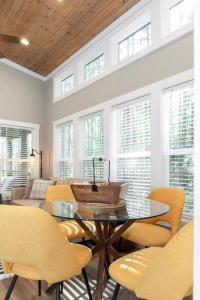 comedor con mesa de cristal y sillas amarillas en Tikabee Timbers - Minutes to Mentone & Desoto Falls, en Mentone