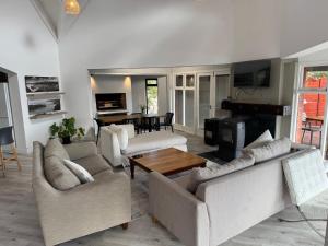 a living room with two couches and a piano at Wilderness deckhouse. views!/sun/sea/river/kayaks in Wilderness
