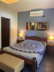 a bedroom with a bed and a fan on the wall at Alma Quinta Maschwitz muy cerca de Temaiken in Maquinista Savio +35 photos