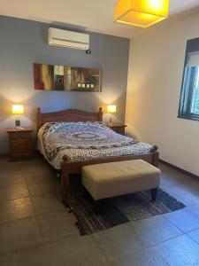 ein Schlafzimmer mit einem Bett, einer Bank und zwei Lampen in der Unterkunft Increible casa Quinta en Ing Maschwitz in Maquinista Savio