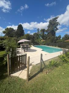einen Pool mit einem Tisch und einem Zaun in der Unterkunft Increible casa Quinta en Ing Maschwitz in Maquinista Savio