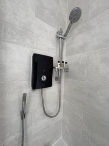 a shower with a shower head in a bathroom at Spacious John York House & Parking in Doncaster
