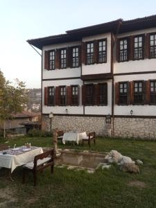 a building with two tables and a dog in front of it at Han Safranbolu in Safranbolu
