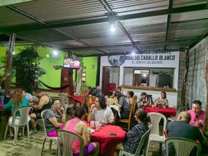 a group of people sitting at tables in a restaurant at Rancho Caballo Blanco in Moyogalpa