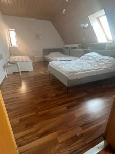 a bedroom with two beds and a wooden floor at 3-Zimmer Monteurwohnung in Göppingen