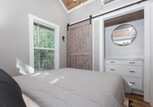 Un dormitorio con una cama y un espejo y una ventana. en Tikabee Timbers - Minutes to Mentone & Desoto Falls, en Mentone