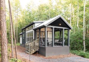 Una pequeña casa en el bosque con un porche. en Tikabee Timbers - Minutes to Mentone & Desoto Falls, en Mentone