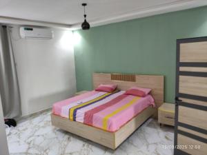 a bedroom with a bed with pink and colorful sheets at Appartement meublé Thiès in Thiès