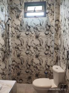 a bathroom with a black and white wallpaper with a toilet at Appartement meublé Thiès in Thiès