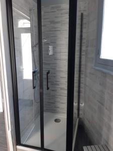 a shower with a glass door in a bathroom at Maison à 50m de la plage in Gâvres +2 photos