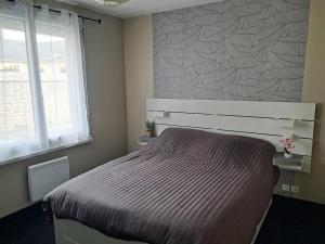 a bedroom with a bed and a window at Maison à 50m de la plage in Gâvres