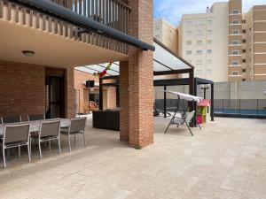 a patio with chairs and a table on a building at Villa con barbacoa para familias in Mareny Blau