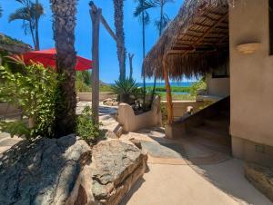 トドス・サントスにあるAlegria Suites at La Poza Beachのヤシの木が茂るビーチと建物のあるリゾート