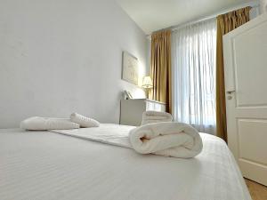 ブカレストにあるZenith Central Address Apartment with Parkingの白いベッドルーム(ベッドにタオル2枚付)